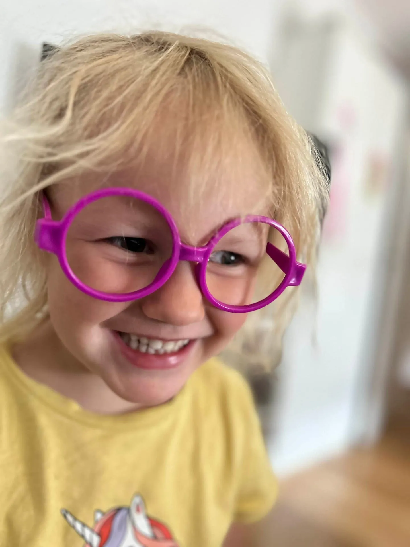 Lachendes Mädchen mit großer pinkfarbener Spielbrille