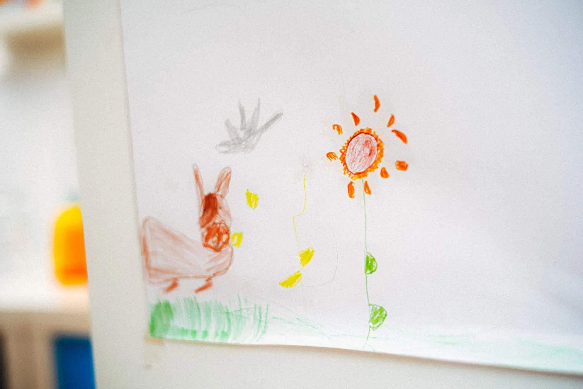 Kinderzeichnung mit Blumen und Sonne an der Wand der Praxis